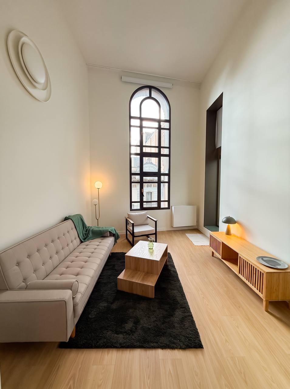 Duplex living room with an arched floor-to-ceiling window